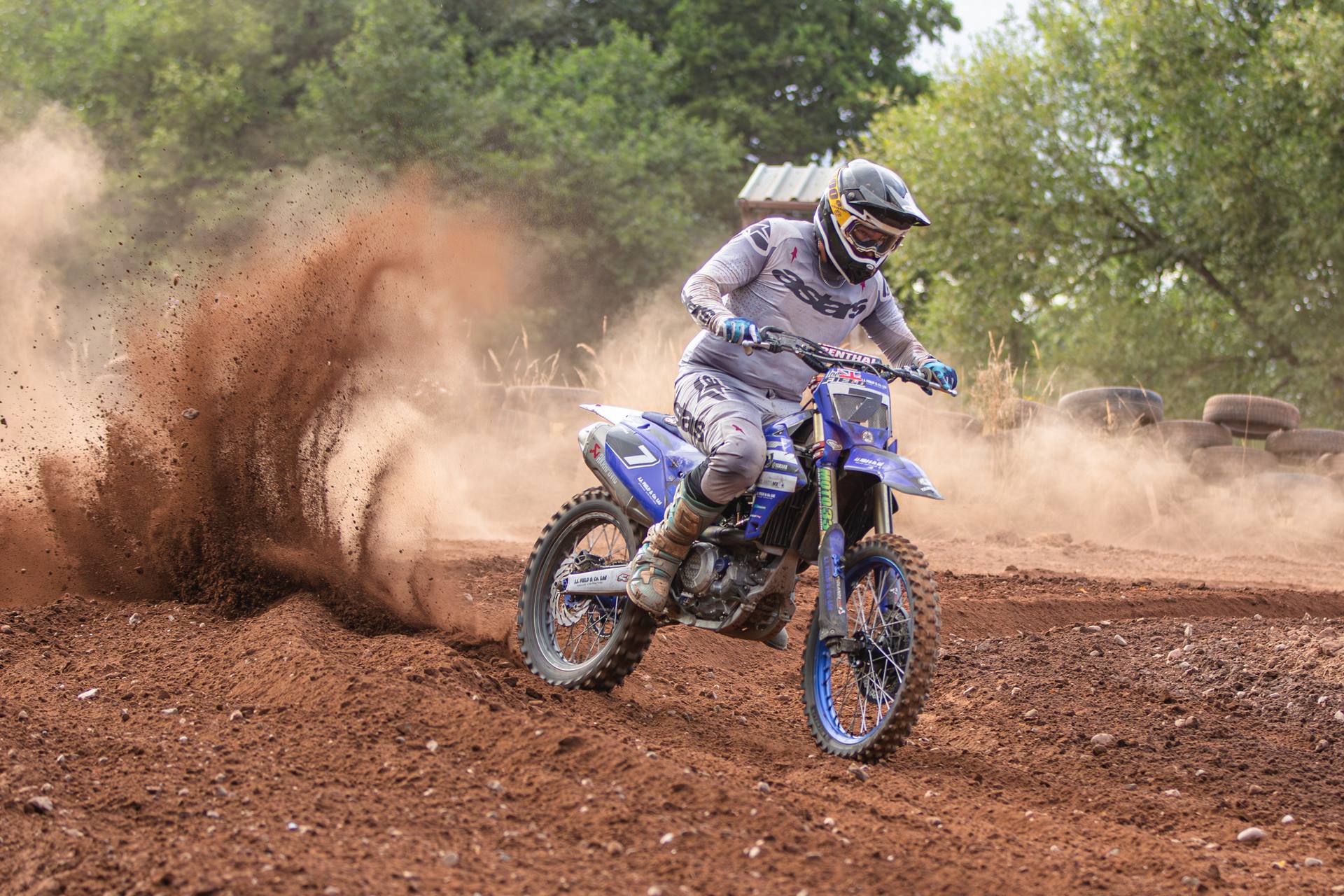 Rider on a blue Yamaha throwing up roost in a corner at J4M54