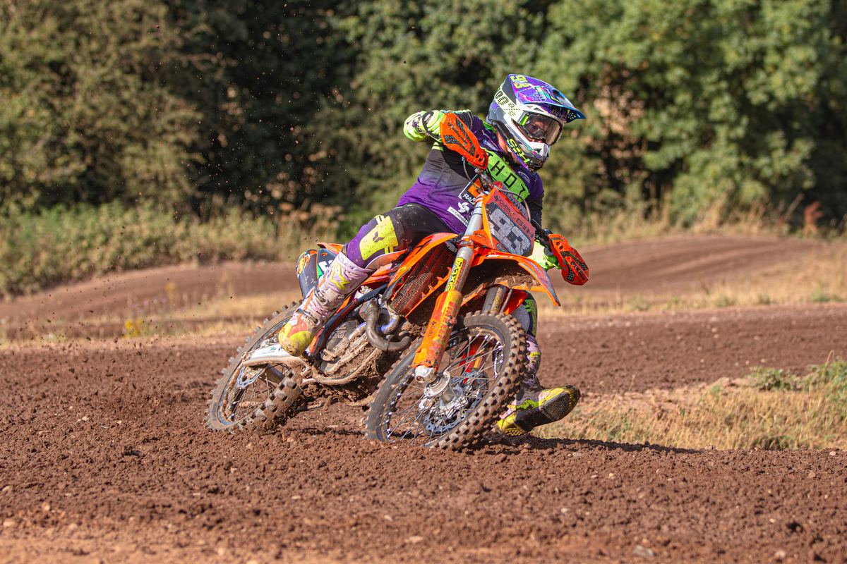 Rider on an orange bike leaning into a corner at J4M54